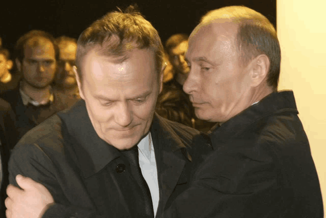 two men are hugging each other and one is wearing a black jacket