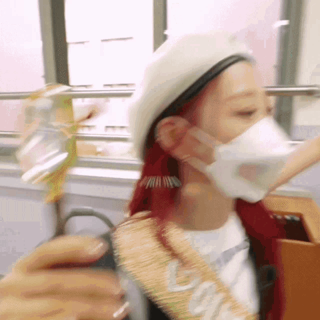 a woman with red hair wearing a white beret and a white face mask