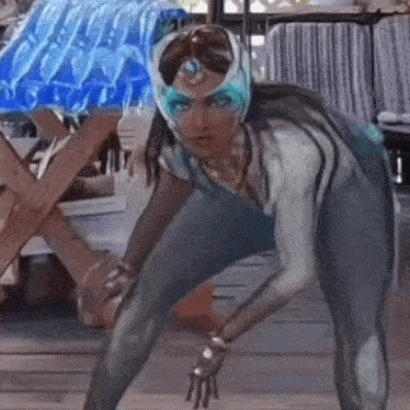 a woman in a superhero costume is kneeling down in front of a table .