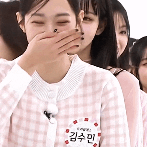 a girl with a name tag that says kimsumin covering her mouth with her hand