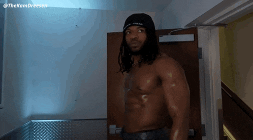 a shirtless man wearing a black hat that says that