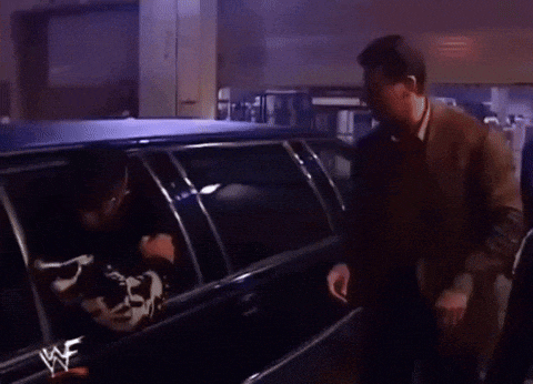 a wrestler is getting out of a limousine with a cow on the back