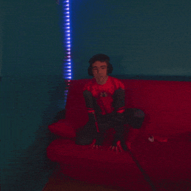 a blurry picture of a person sitting on a red couch in a dark room