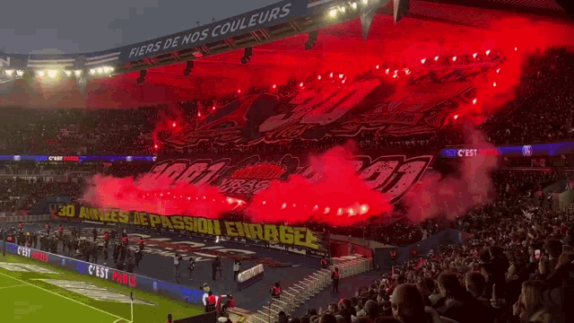 a stadium full of people with a sign that says fiers de nos couleurs