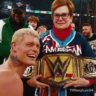 a woman in an american jersey holds a wrestler 's championship belt