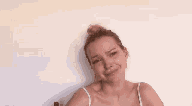 a woman with her hair in a bun and black nails is smiling .