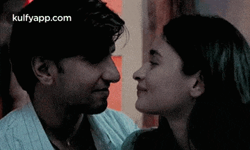 a man and a woman are kissing each other in a dark room .