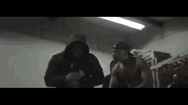 two men in hoodies are standing next to each other in a room .