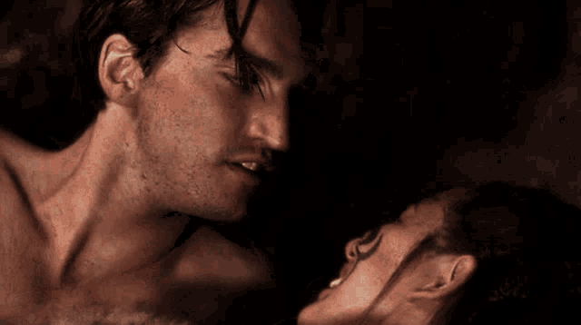 a man and a woman are kissing in the dark .