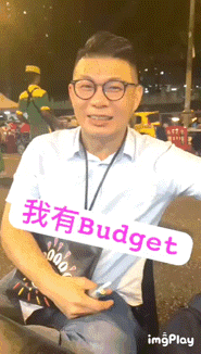 a man holding a sign that says budget
