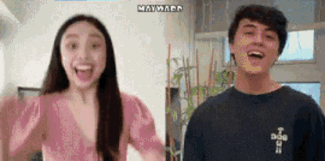 a man and a woman are laughing together in a living room .