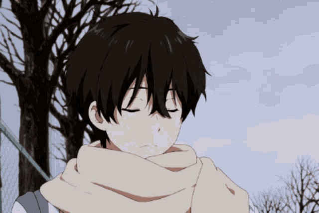 a boy with a scarf around his neck is looking down