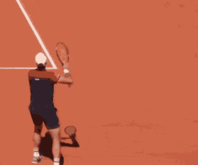 a man is holding a tennis racket on a tennis court
