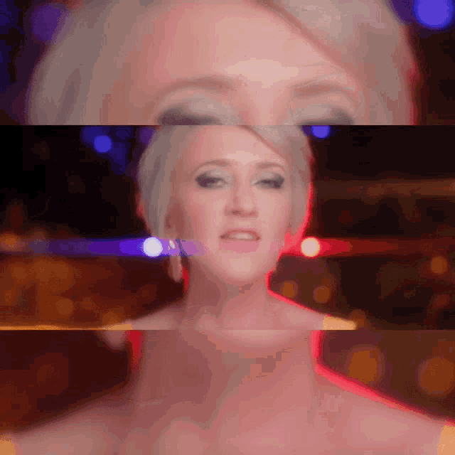 a close up of a woman 's face with a blurred background of lights