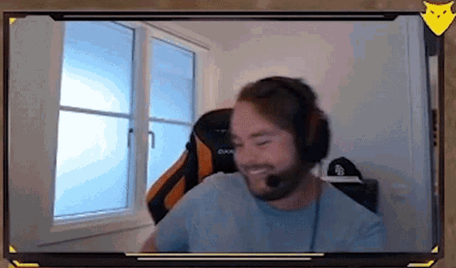 a man with a beard is wearing headphones and smiling while sitting in a chair .