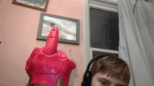 a boy wearing headphones stands in front of a picture of a man