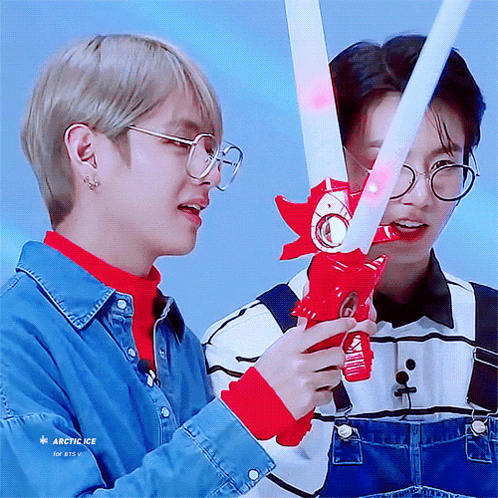 two boys wearing glasses and overalls are playing with a toy sword which says arctic ice on it