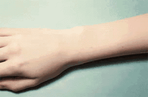 a small clock on a person 's wrist that shows the time as 3:00