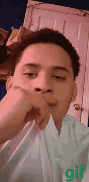 a gif of a man covering his mouth with his hand and a door in the background