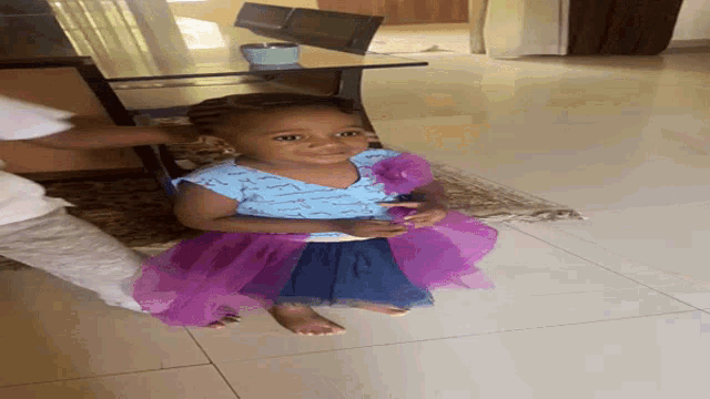 a little girl in a blue and purple dress