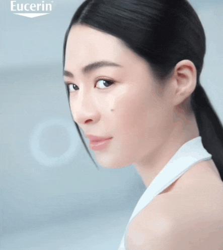a woman 's face is shown with the eucerin logo behind her