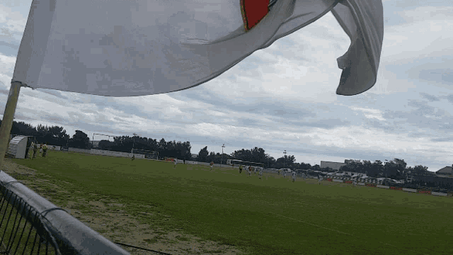 a soccer field with a flag flying in the wind