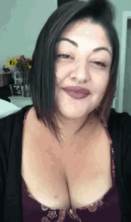 a woman with a nose ring and a very large breast is smiling .
