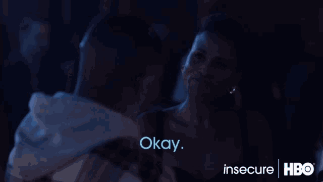 a woman is smiling and says okay in a dark room