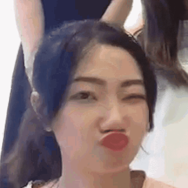 a woman is making a funny face with her eyes closed and her mouth open .
