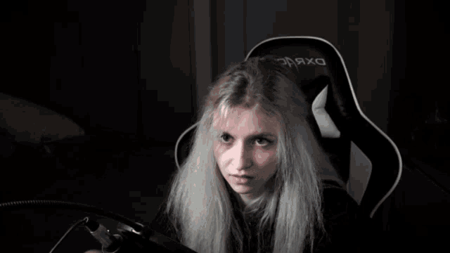 a woman sits in a chair that says opax on it