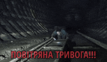 a man is crawling through a dark tunnel