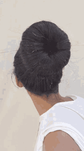 the back of a woman 's head with a bun