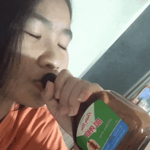 a woman is drinking from a bottle that says big daddy