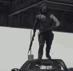 a person standing on top of a car with a gun