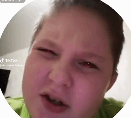 a close up of a person 's face in a circle with red eyes .