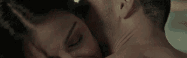 a man and a woman are kissing with their mouths open .