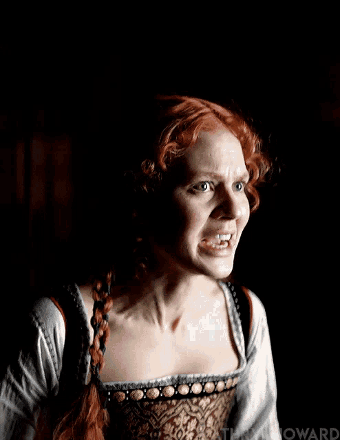 a woman with red hair and braided hair is making a funny face