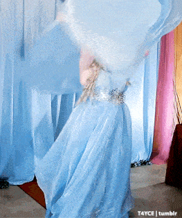 a woman in a blue dress is dancing in front of a blue curtain which says t4yce tumblr on the bottom