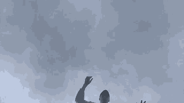 a person in black pants is falling through the air with their arms outstretched