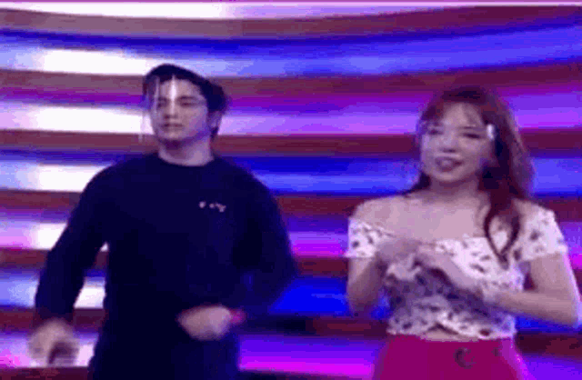 a man and a woman are standing next to each other on a stage .