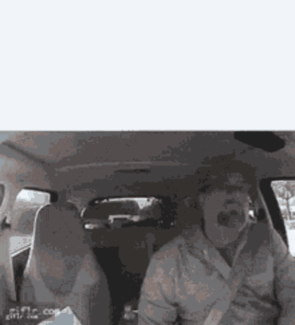 a man is driving a car with his mouth open