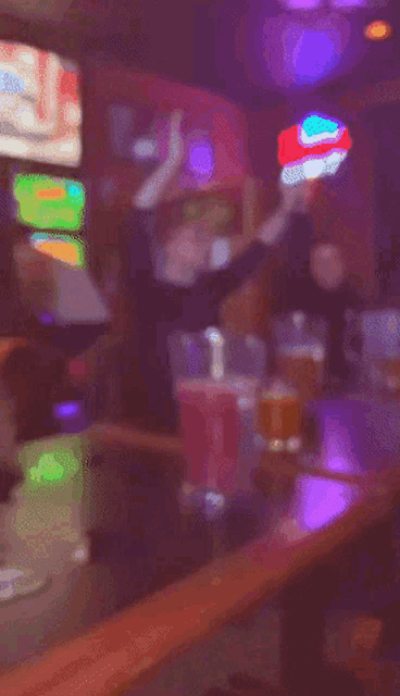 a man giving the middle finger in front of a pitcher of red liquid