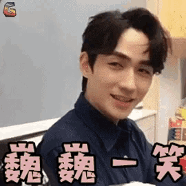 a young man is smiling and making a funny face in a kitchen .