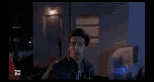a blurry picture of a person standing in front of a blue light that says sv ev on the bottom