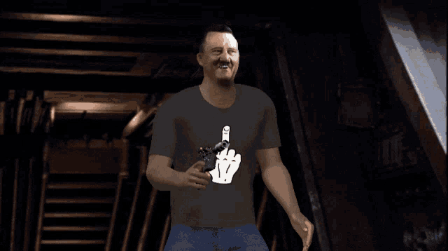 a man is holding a gun and wearing a t-shirt that has a middle finger on it