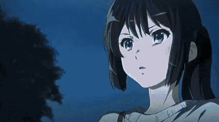 a girl with black hair and blue eyes is standing in front of a tree in the dark .