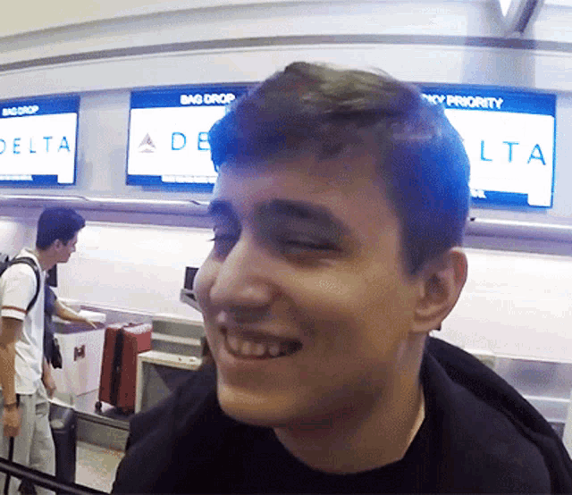 a man is smiling in front of a screen that says delta