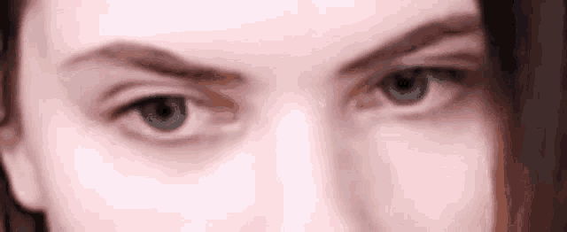 a close up of a woman 's blue eyes looking at the camera .