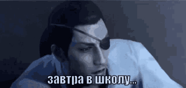 a man with an eye patch on his eye is sitting in a dark room and talking in a foreign language .