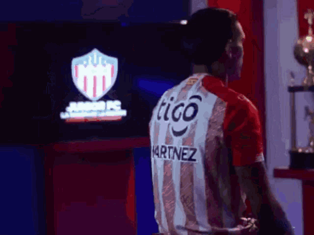 a man wearing a red and white striped shirt that says tigo martinez